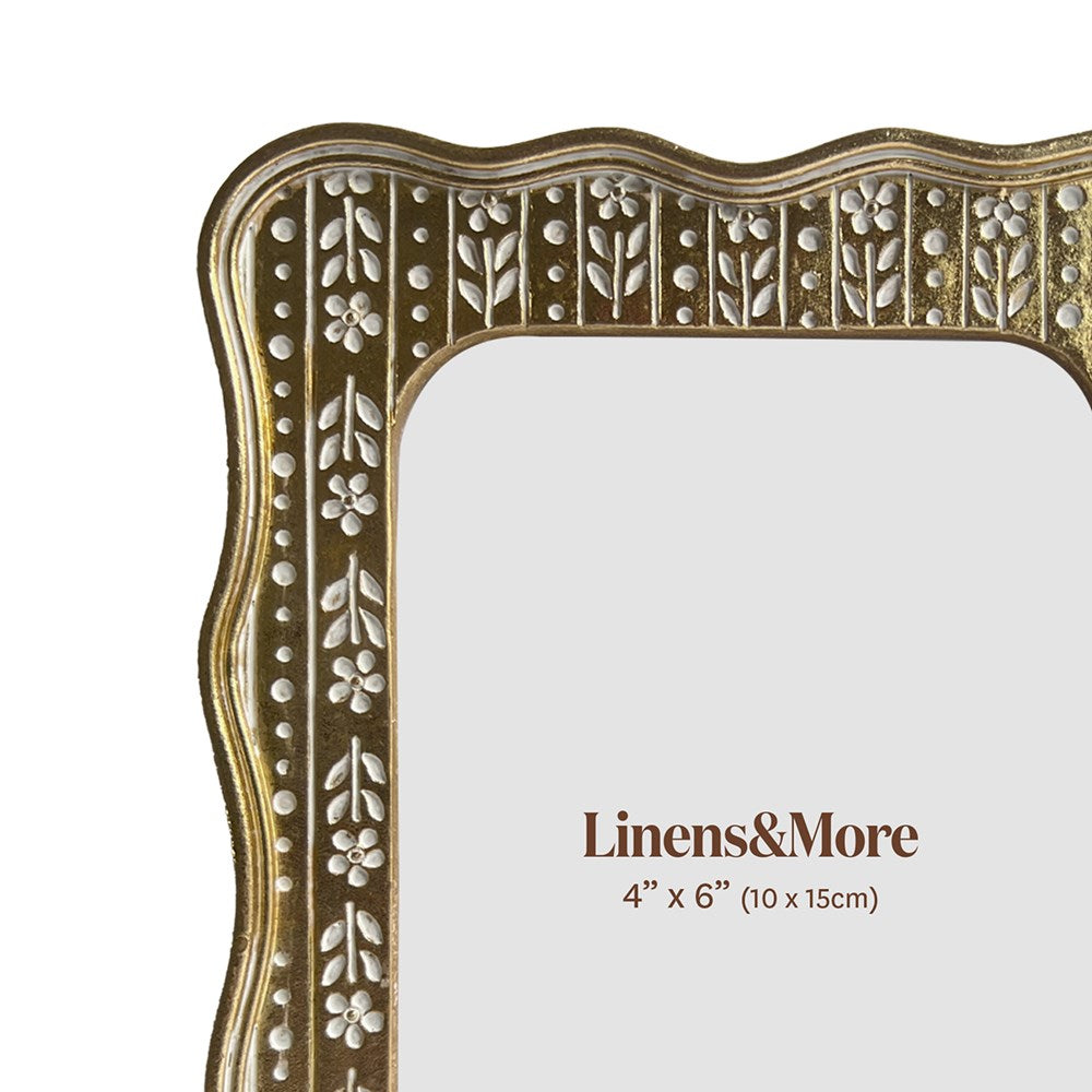 Decorative gold frame with floral patterns on a white background, featuring 'Linens & More' branding.