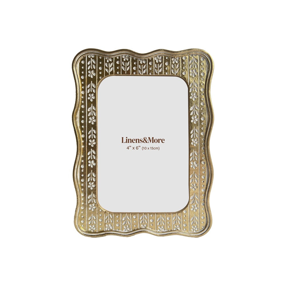 Decorative gold photo frame with 'Linens & More' branding on a white background