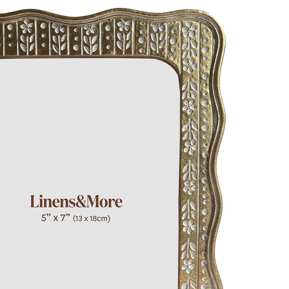 Decorative gold frame with floral patterns on a white background, featuring 'Linens & More' branding.