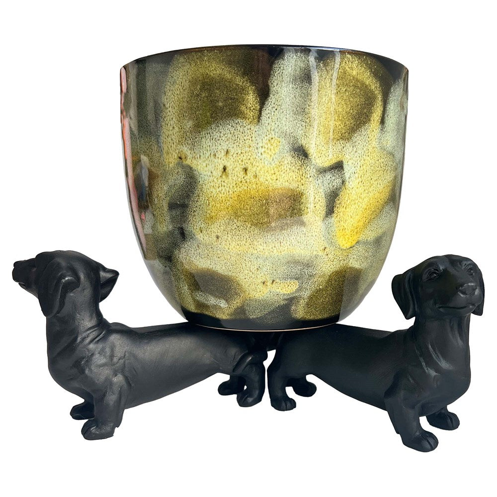 Dachshund dog pot holders balancing a planter pot on a white background