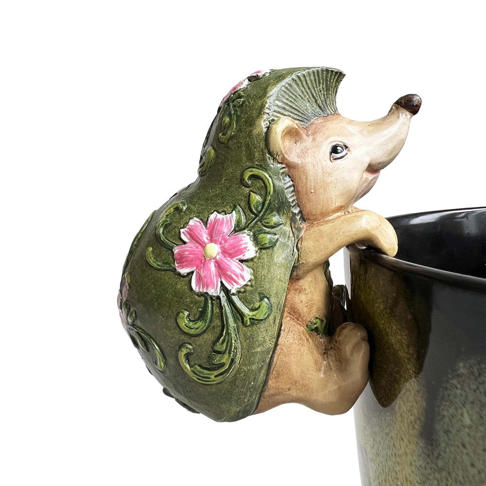 Decorative hedgehog with a flower on its back hanging on a planter pot