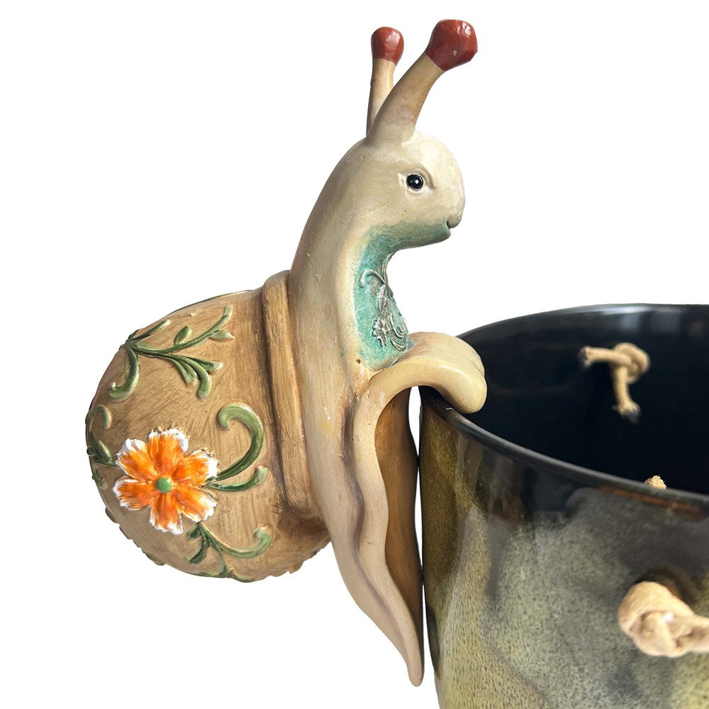 Snail hanging on a pot on a white background