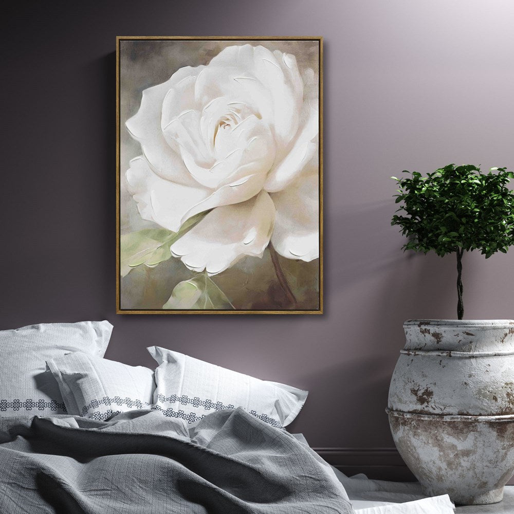 Framed artwork of a white gardenia on a wall above a bed with a potted plant.