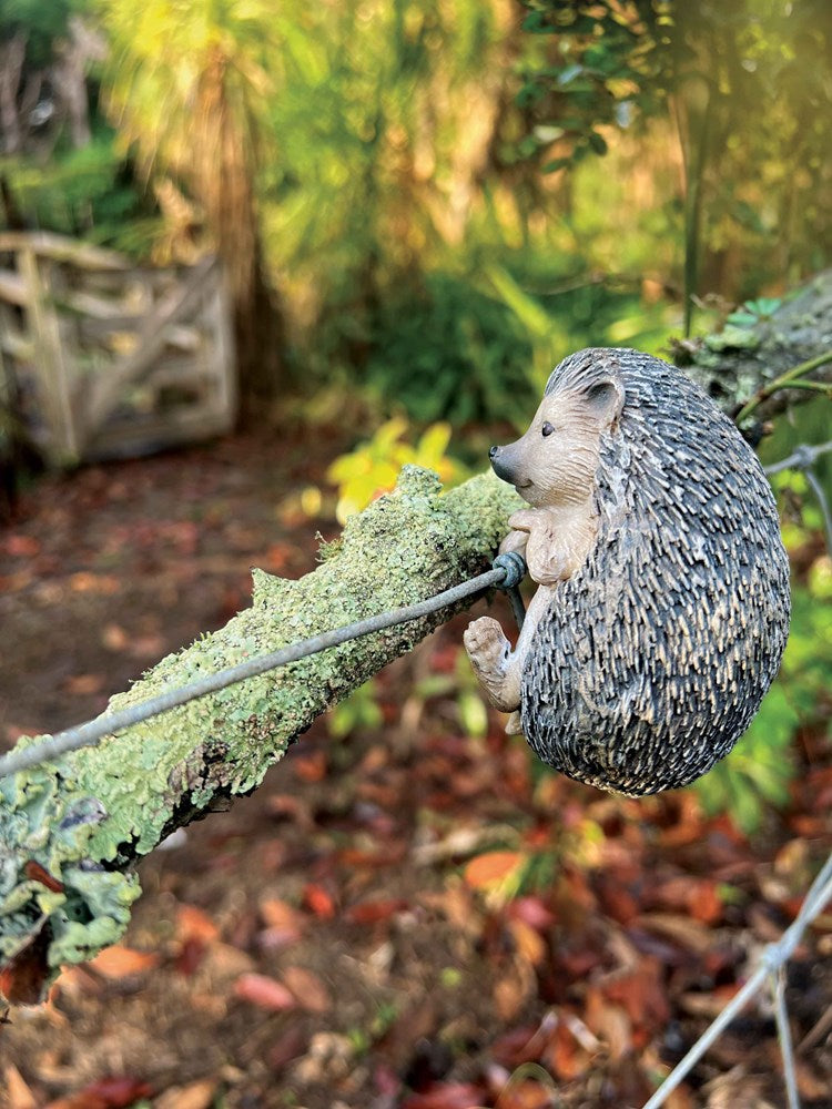 Hedgehog figurine on a branch with a natural background