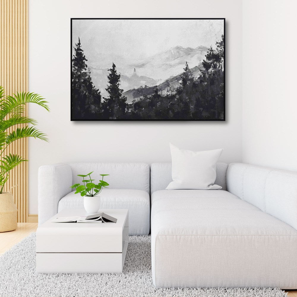 Modern living room with a white sofa, coffee table, and framed black and white mountain landscape art.