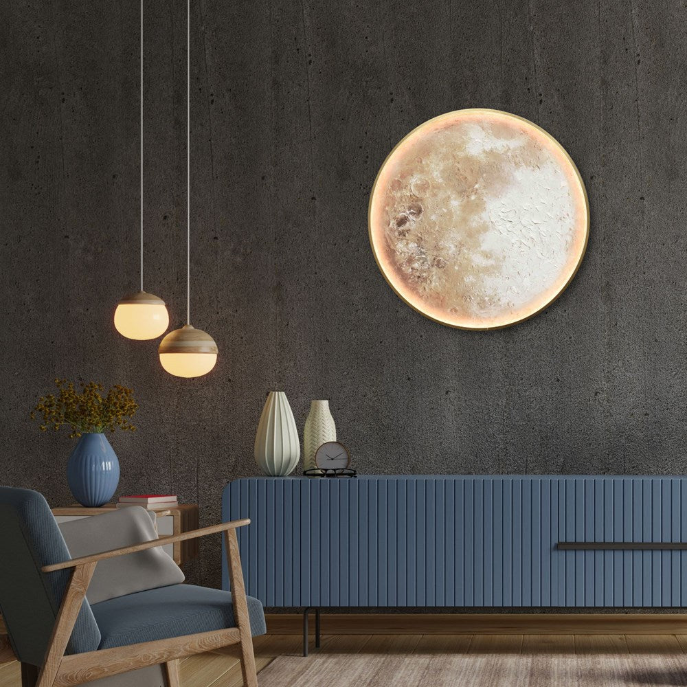 Modern living room with a LED moon wall art, blue sofa, and hanging lights.