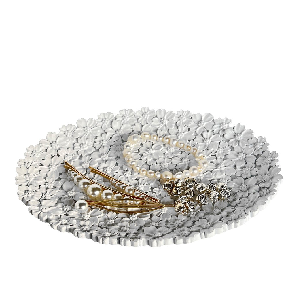 Flower dish displaying jewellery on a white background