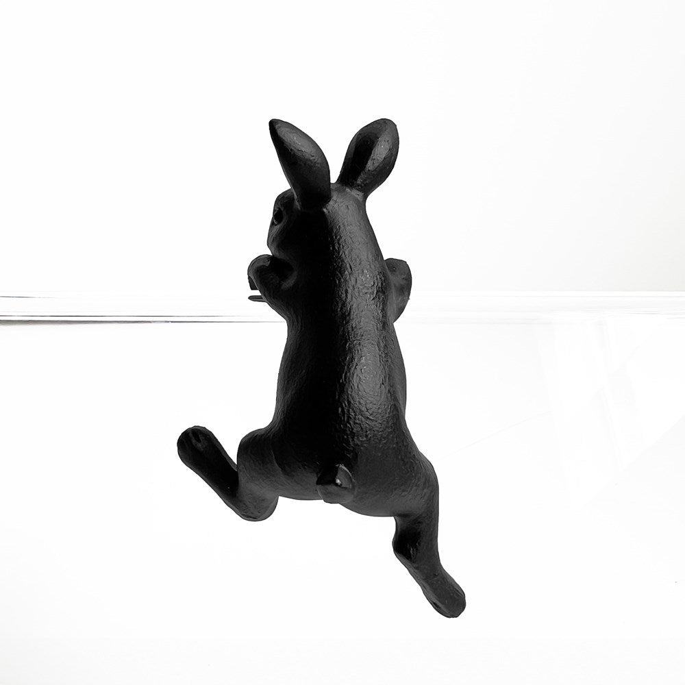 Black cast iron dog-shaped hook on a white background