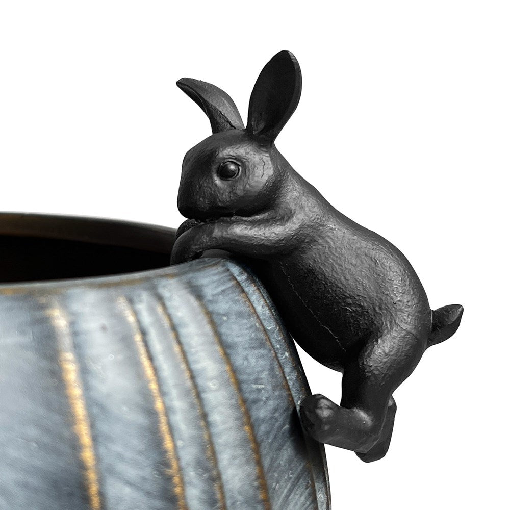 Decorative black rabbit sculpture on a pot with a white background