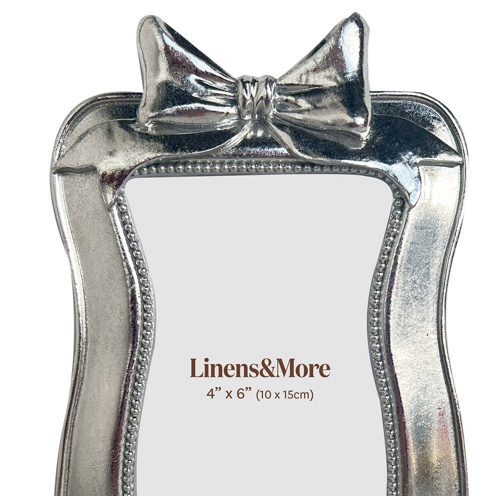 Silver bow-shaped photo frame  on a white background