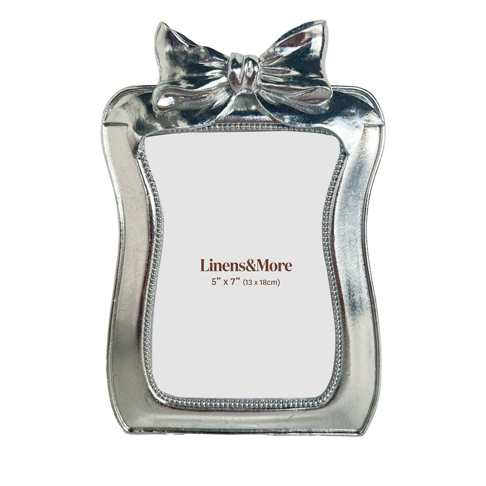 Silver bow-shaped picture frame with 'Linens&More' branding on a white background