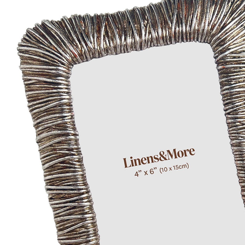 Decorative wire photo frame with 'Linens & More' branding on a white background