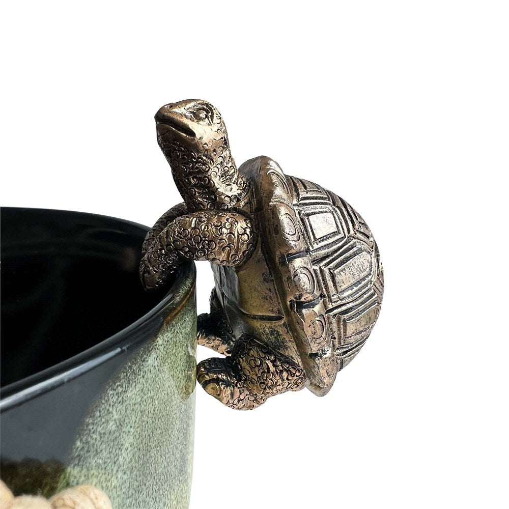 Gold tortoise hanging on a planter pot