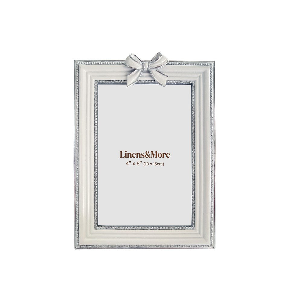 White and silver picture frame with a bow on a white background