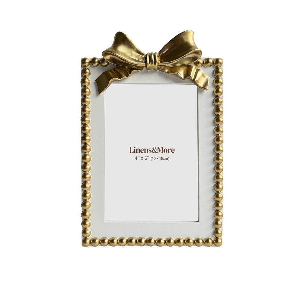Gold picture frame with a decorative bow on a white background