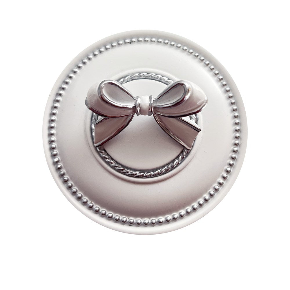 Decorative trinket box lid with a white and silver bow on a white background