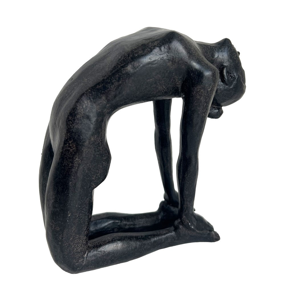 Black sculpture of a woman in a stretching pose on a white background