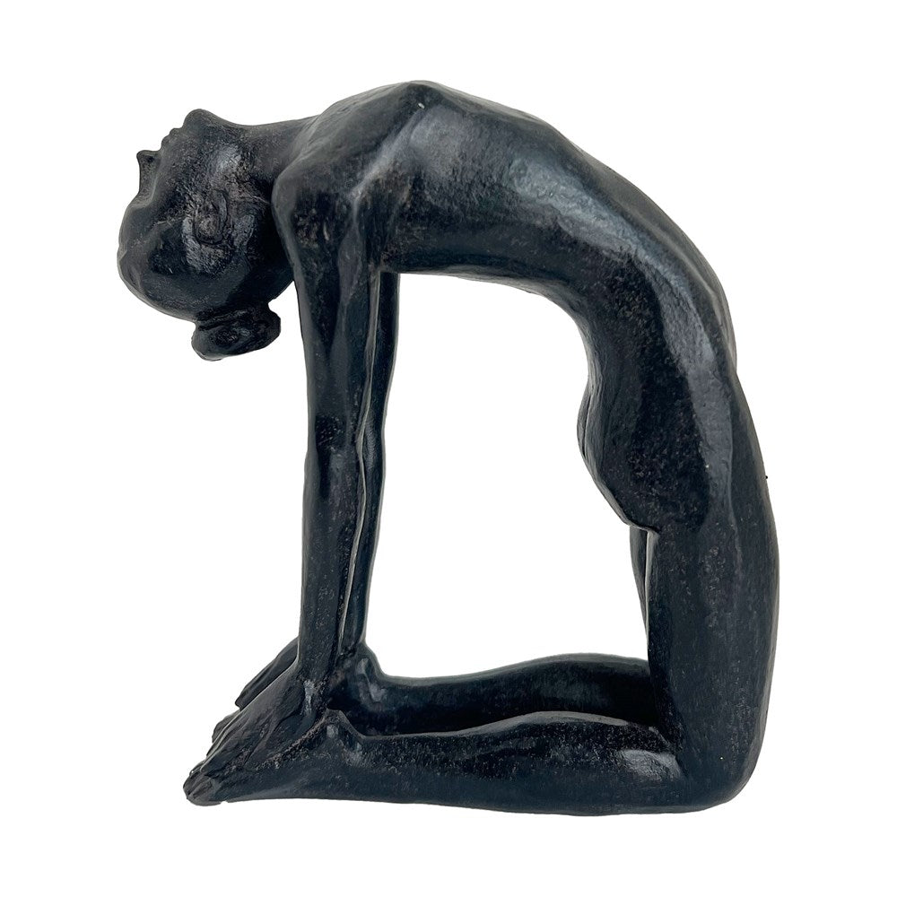 Black sculpture of a woman in a yoga pose on a white background